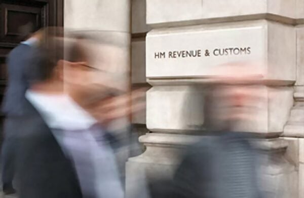 Blurred people near HM Revenue and Customs sign.