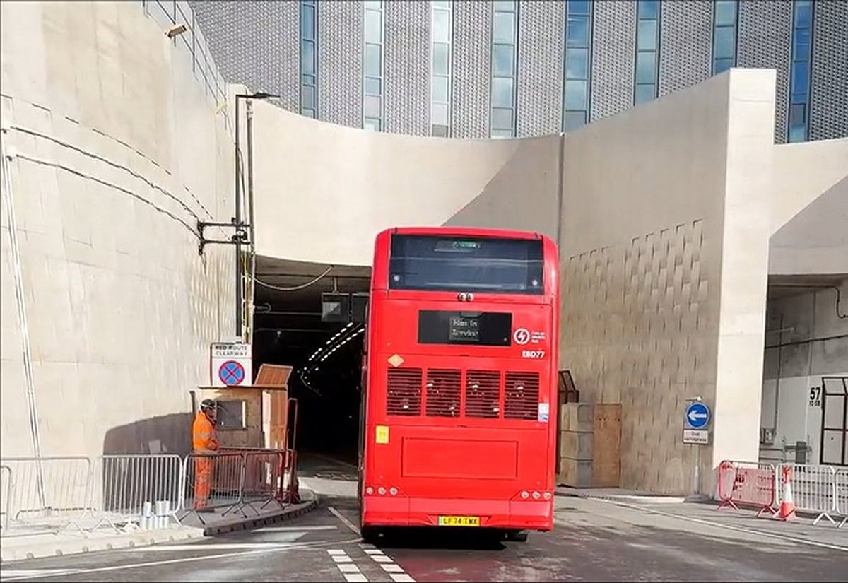 Red bus exiting Silvertown Tunnel; key route for chauffeur drivers in London.